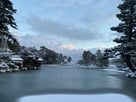 早朝の兼六園にて、雪化粧した霞ヶ池と内橋…