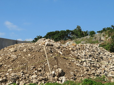 グスク横の工事現場の掘り返した土石越しの城跡