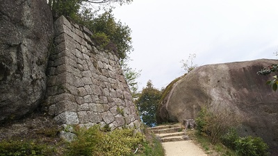 本丸跡の石垣（左）と馬洗岩